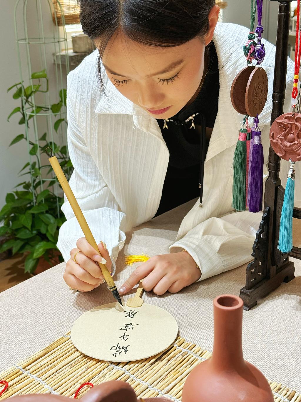 南关岭校区汽车与船舶工程学院学生在团扇上进行书法文创.jpg