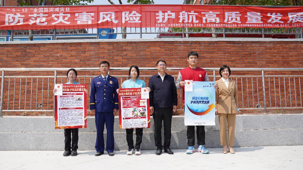 图6：领导为学生代表发放防灾减灾主题宣传海报（图片：刘浩林）.jpg